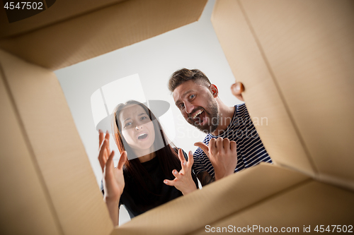 Image of The couple unpacking and opening carton box and looking inside