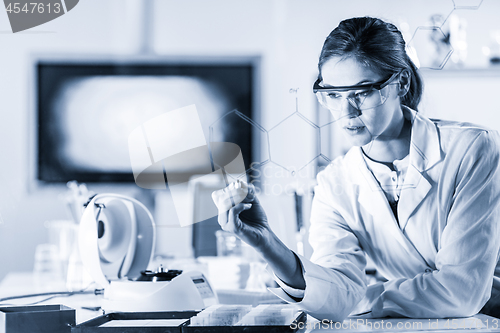 Image of Portrait of a confident female researcher in life science laboratory writing structural chemical formula on a glass board.
