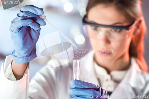 Image of Young scientist pipetting in life science laboratory.