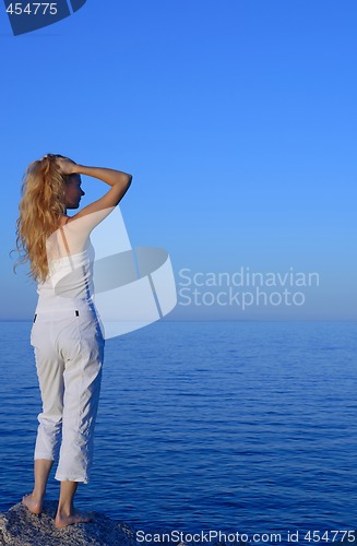 Image of Beautiful young woman looking at the sea