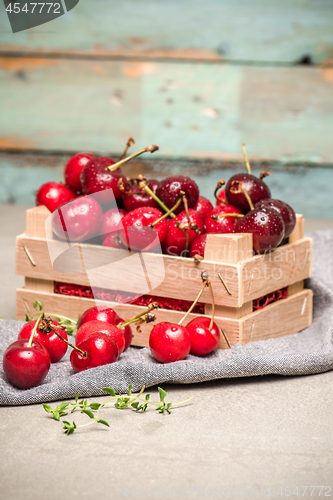 Image of Red ripe cherries in small wooden box