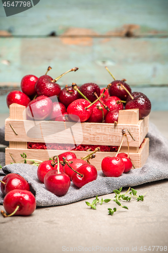 Image of Red ripe cherries in small wooden box