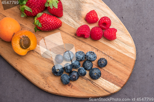 Image of Wooden board with fresh organic fruit and berries
