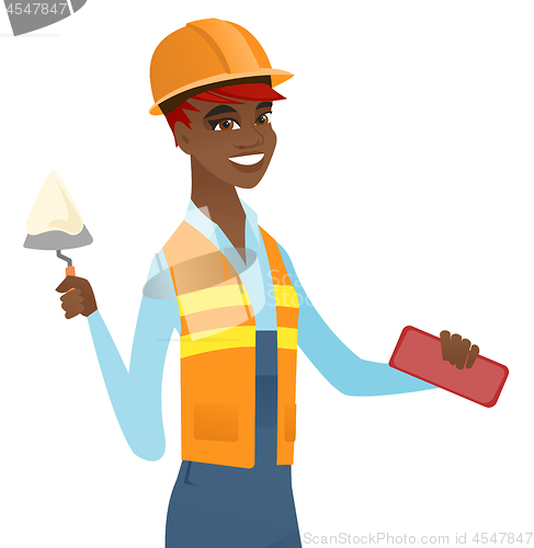 Image of African bricklayer working with spatula and brick.
