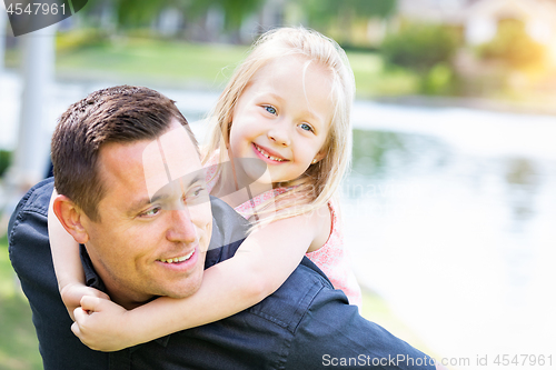 Image of Young Caucasian Father and Daughter Having Fun At The Park