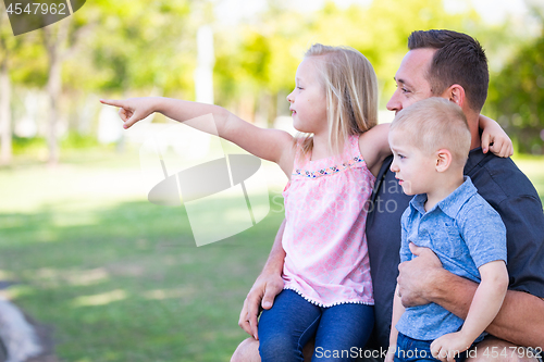 Image of Young Caucasian Dad, Son and Daughter Having Fun In The Park