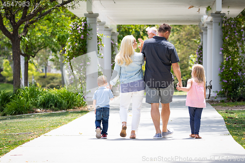 Image of Young Caucasian Family Taking A Walk In The Park