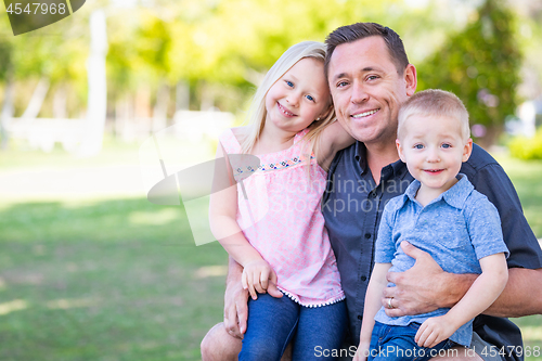 Image of Young Caucasian Dad, Son and Daughter Having Fun In The Park