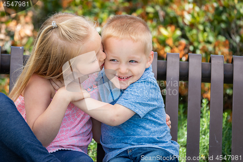 Image of Young Sister and Brother Having Fun On The Bench At The Park