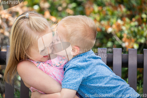 Image of Young Sister and Brother Having Fun On The Bench At The Park