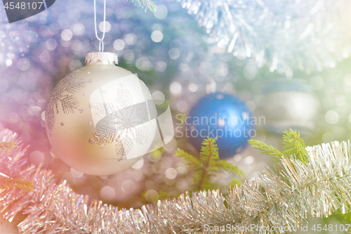 Image of Christmas-tree decoration bauble on decorated Christmas tree bac