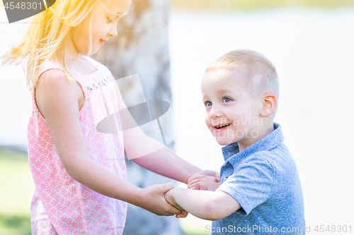 Image of Young Brother and Sister Playing At The Park Togther