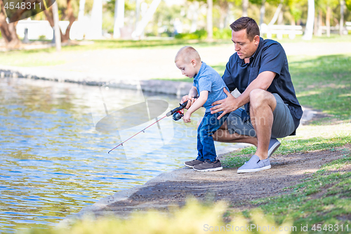 Image of Young Caucasian Father and Son Having Fun Fishing At The Lake