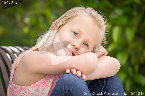 Image of Pretty Young Caucasian Girl Portrait Sitting On The Bench At The