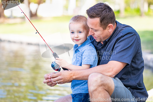 Image of Young Caucasian Father and Son Having Fun Fishing At The Lake