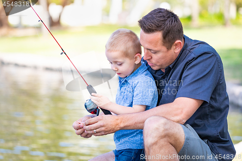 Image of Young Caucasian Father and Son Having Fun Fishing At The Lake