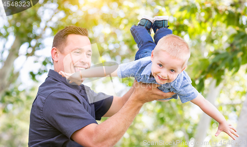 Image of Young Caucasian Father and Son Having Fun At The Park