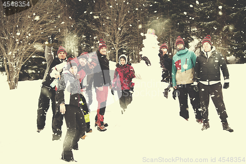 Image of group portait of young people posing with snowman