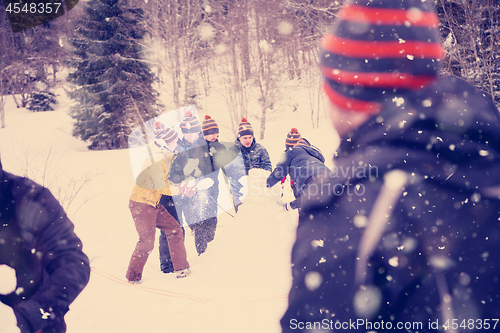 Image of group of young people making a snowman