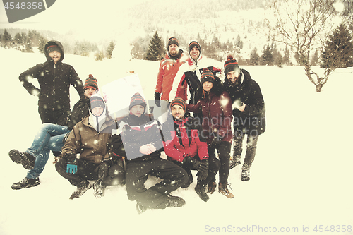 Image of group portait of young people posing with snowman