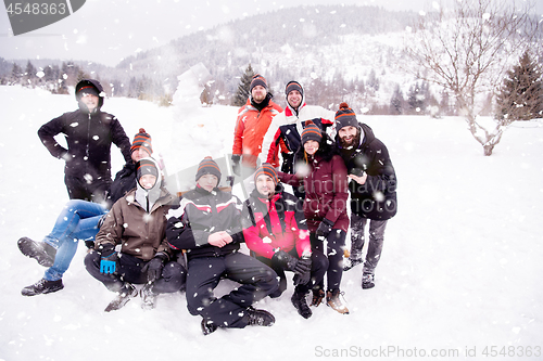 Image of group portait of young people posing with snowman