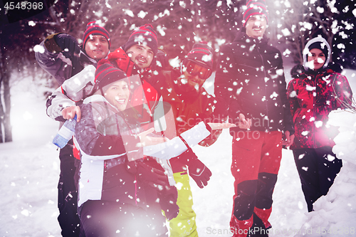 Image of group portait of young people posing with snowman