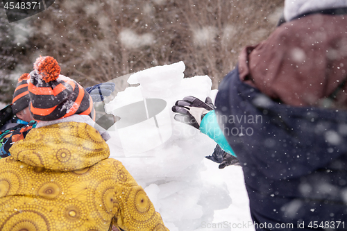 Image of group of young people making a snowman