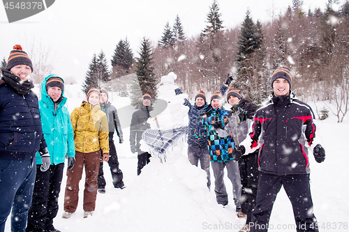 Image of group portait of young people posing with snowman