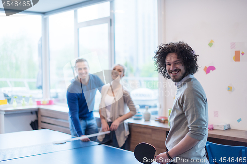 Image of startup business team playing ping pong tennis