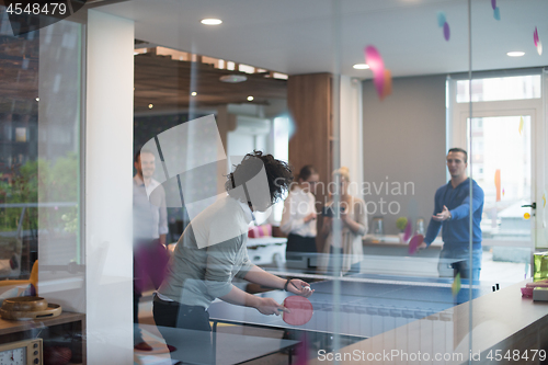 Image of startup business team playing ping pong tennis