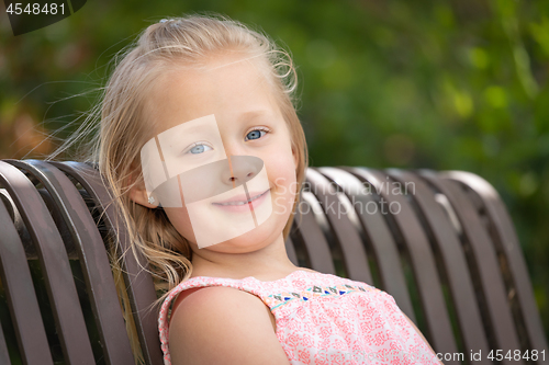 Image of Pretty Young Caucasian Girl Portrait Sitting On The Bench At The