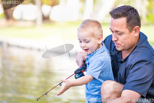 Image of Young Caucasian Father and Son Having Fun Fishing At The Lake