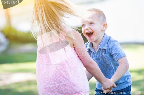 Image of Young Brother and Sister Playing At The Park Togther