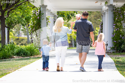 Image of Young Caucasian Family Taking A Walk In The Park