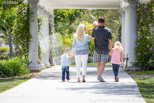 Image of Young Caucasian Family Taking A Walk In The Park