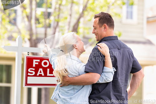 Image of Caucasian Couple Facing and Pointing to Front of For Sale Real E