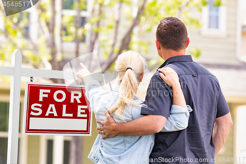 Image of Caucasian Couple Facing and Pointing to Front of For Sale Real E