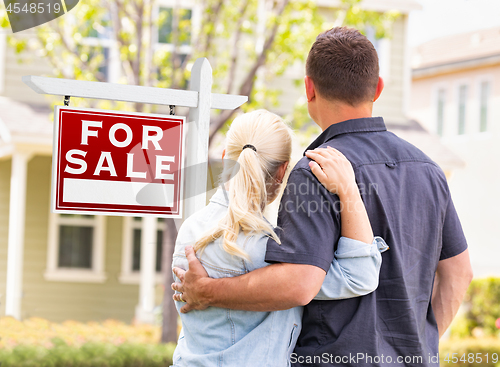 Image of Caucasian Couple Facing Front of Sold Real Estate Sign and House