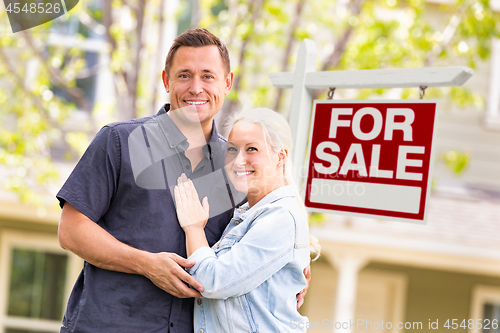 Image of Caucasian Couple in Front of For Sale Real Estate Sign and House