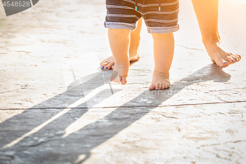 Image of Mother and Baby Feet Taking Steps Outdoors