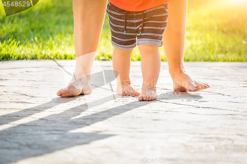 Image of Mother and Baby Feet Taking Steps Outdoors