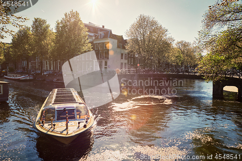 Image of Amsterdam canal with tourist boat
