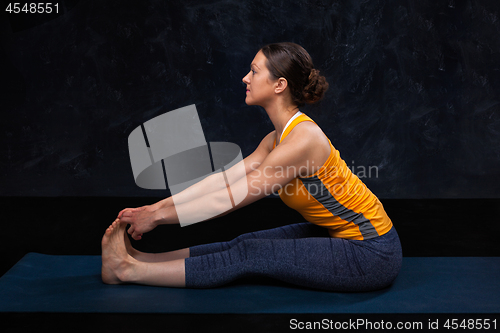 Image of Woman doing Hatha yoga Ashtanga Vinyasa yoga asana Paschimottana