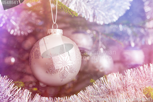 Image of Christmas-tree decoration bauble on decorated Christmas tree bac