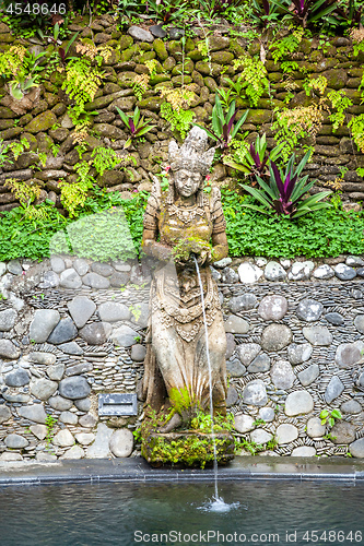 Image of Old stone figural fountain on a pond, Bali