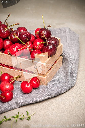 Image of Red ripe cherries in small wooden box