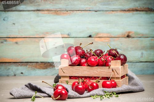 Image of Red ripe cherries in small wooden box