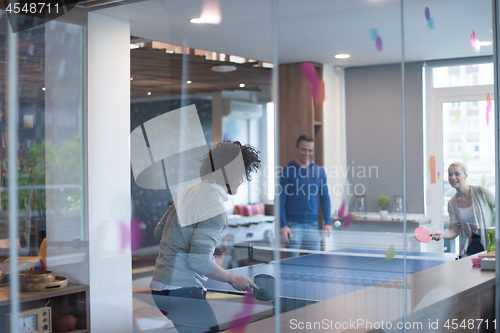 Image of startup business team playing ping pong tennis