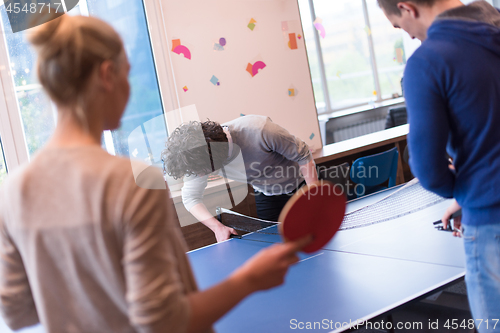 Image of startup business team playing ping pong tennis