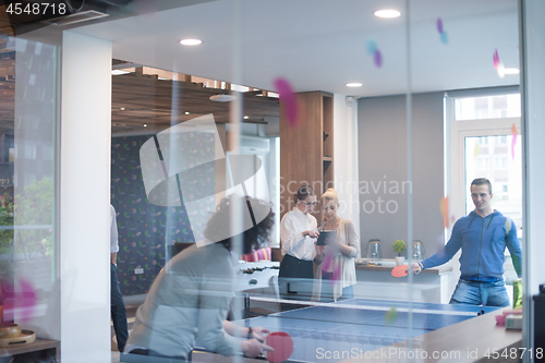 Image of startup business team playing ping pong tennis